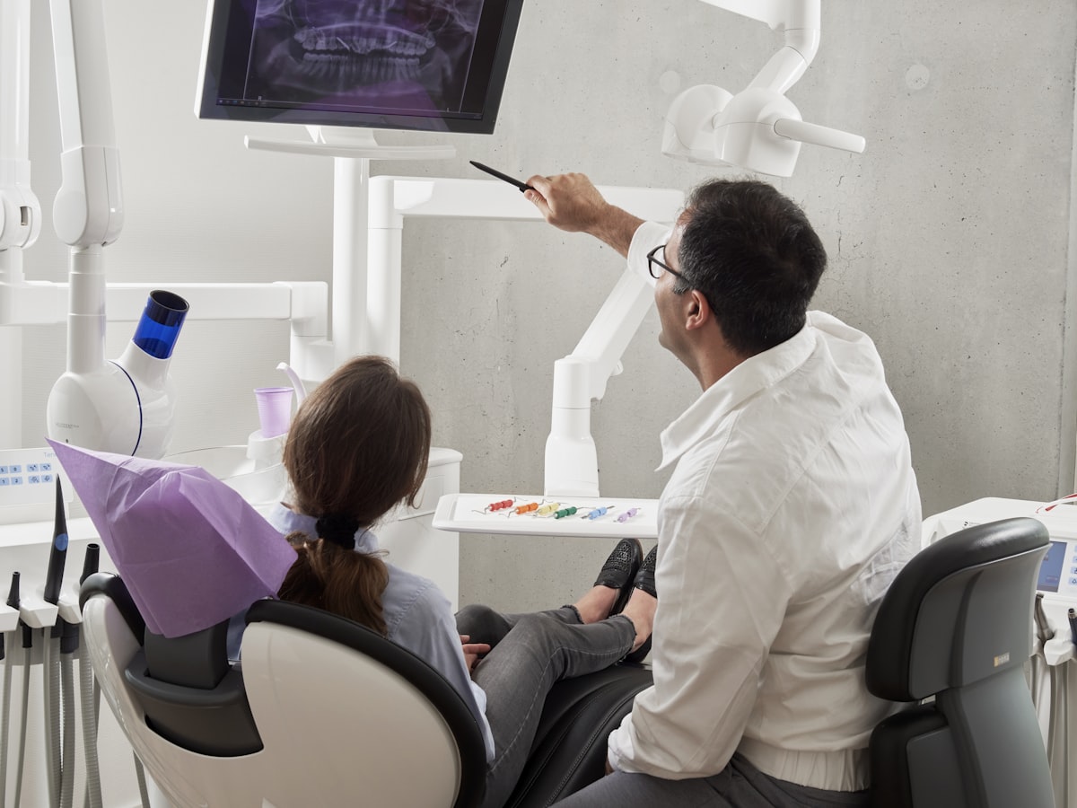 A dentist showing a patient an X-ray in a modern clinic